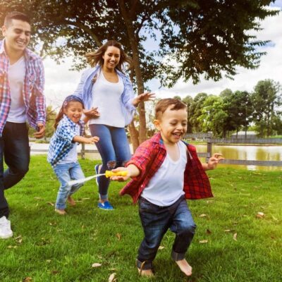 Happy family playing outdoors in park.