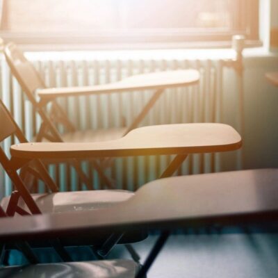 Empty classroom with sunlight on desks.