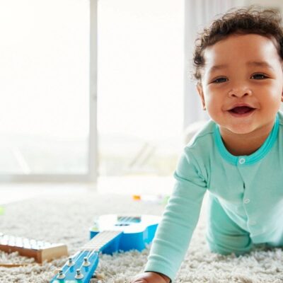 A baby is playing with toys in a living room.