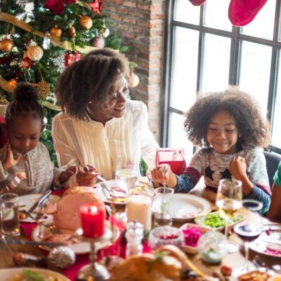 A family sits at a table and eats a christmas dinner.