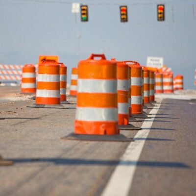 A line of orange and white construction cones on a road.