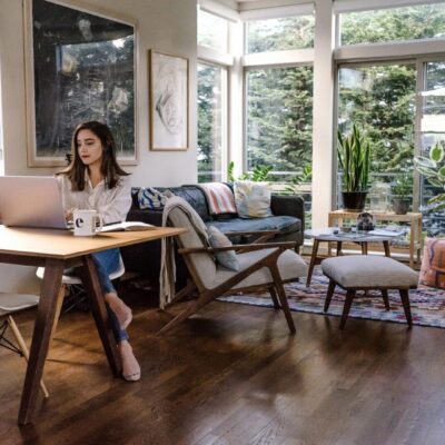 A woman working on her laptop in a living room.
