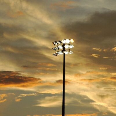 A stadium light with a cloudy sky in the background.