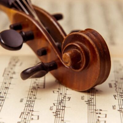 A violin rests on top of a sheet of music.