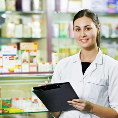Pharmacist writing on clipboard in pharmacy.