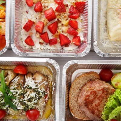 A variety of food in plastic containers on a white background.