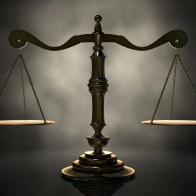 A scale of justice on a dark background.