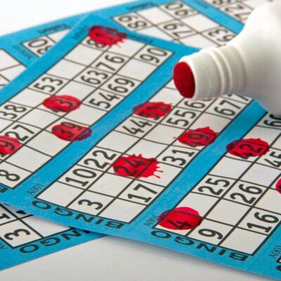 A bottle of water and bingo cards on a table.