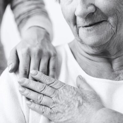 Elderly person comforted by caregiver.