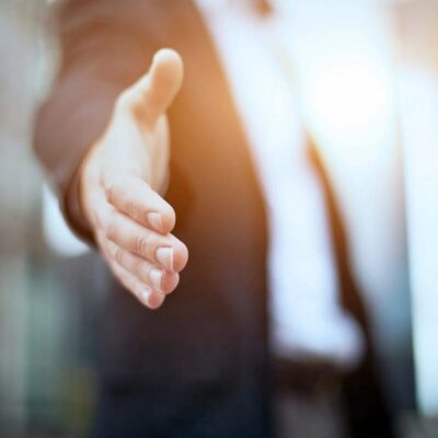 Businessperson offering handshake, partnership.
