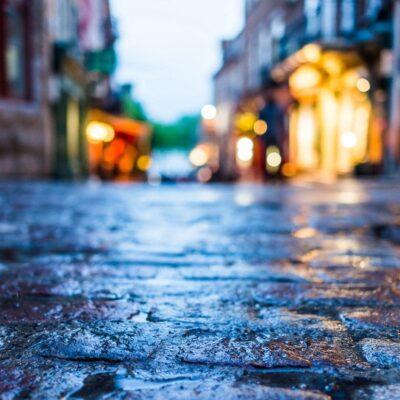 Wet cobblestone street at night.
