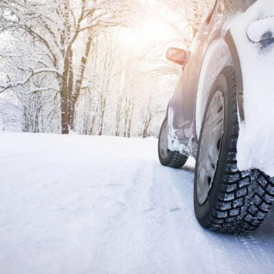 A car is covered in snow on a snowy road.