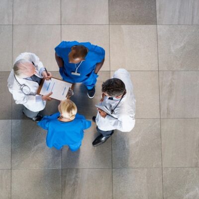 A group of doctors standing around a tiled floor.
