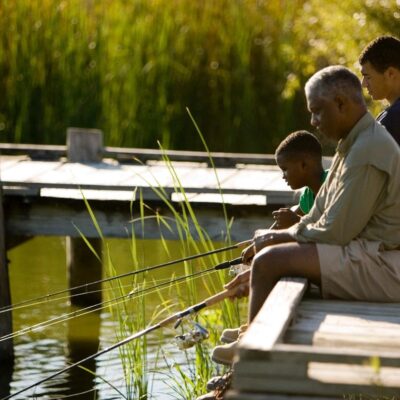 A man and his son are fishing on a dock.