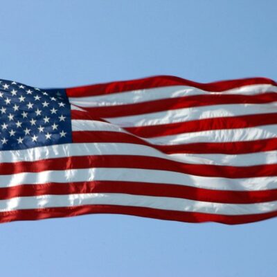 A flag flying in the sky on a sunny day.