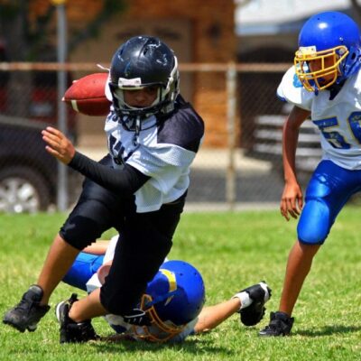 A group of kids playing football on a field.
