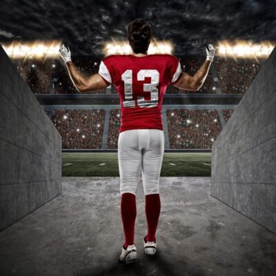 A football player standing in an empty stadium.