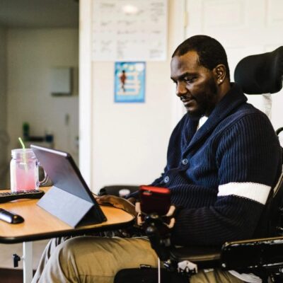 A man in a wheelchair using a laptop.