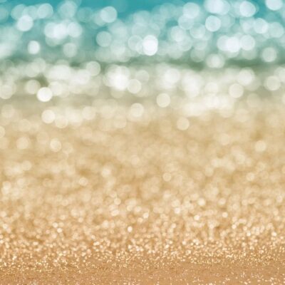 Blured beach bokeh, blue water, gold sand.