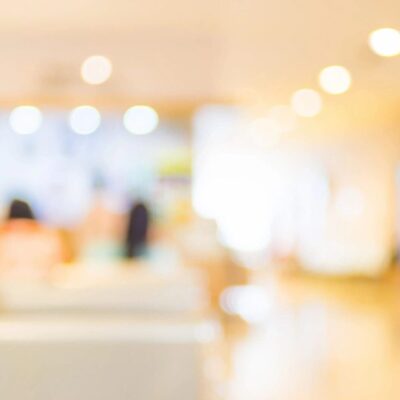 A blurry image of people sitting in a waiting room.