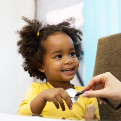 A little girl is being examined by a doctor with a stethoscope.