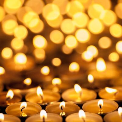 A group of candles in a row with a blurred background.