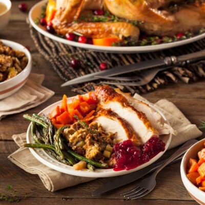 A table full of thanksgiving food on a wooden table.