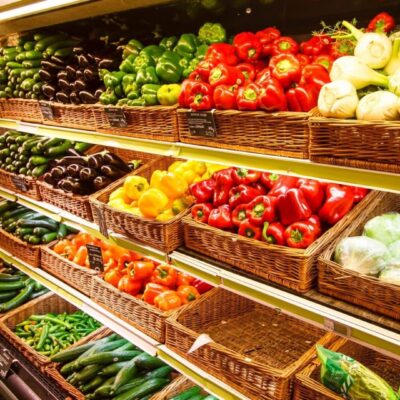 A display case filled with lots of different fruits and vegetables.