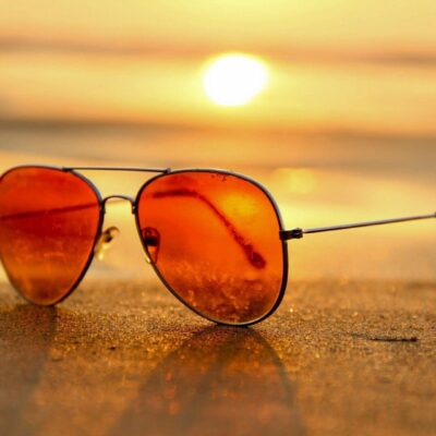 Sunglasses on beach at sunset.