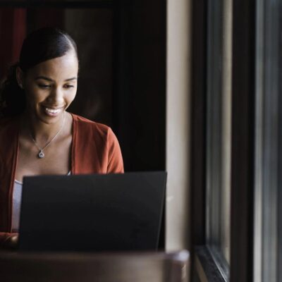 A woman using a laptop in a cafe.