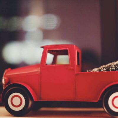 A red toy truck sits on a window sill.