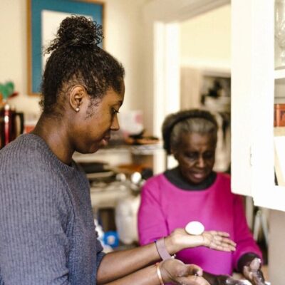 Two women in a kitchen preparing food.