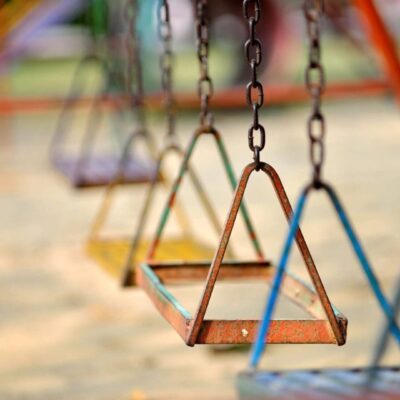 A group of colorful swings in a playground.