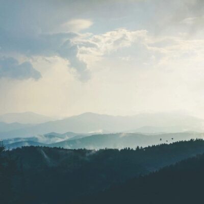 Misty mountains, cloudy sky, serene view.