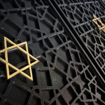 A golden star of david on a metal gate.