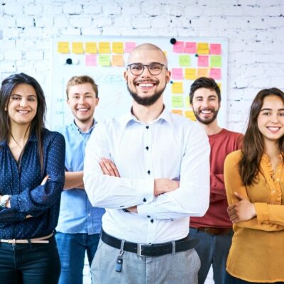 A group of business people standing in front of a white wall.