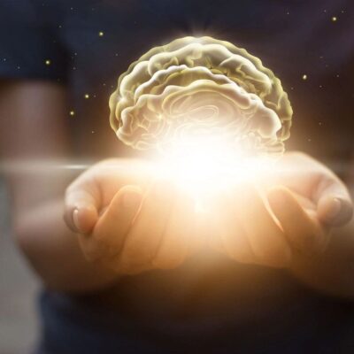 A woman holding a glowing brain in her hands.