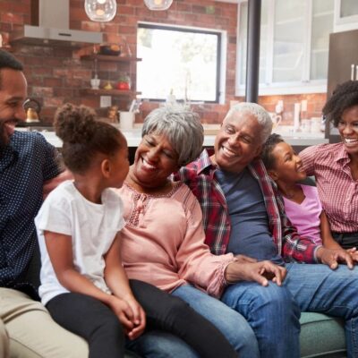 A family sitting on a couch in a living room.