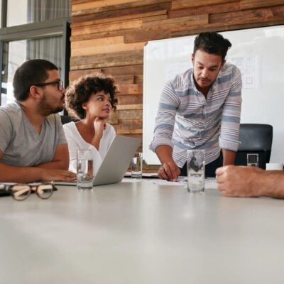 A group of people sitting around a table in a meeting.
