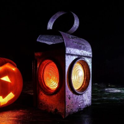Lit jack-o'-lantern and antique lantern.
