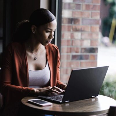A woman sitting at a table using a laptop.