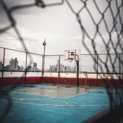 A basketball court with a fence in the background.