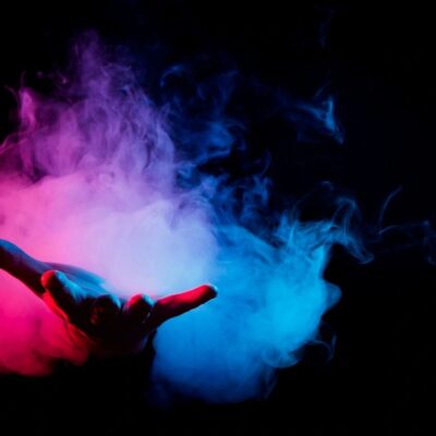 A hand with smoke coming out of it on a black background.