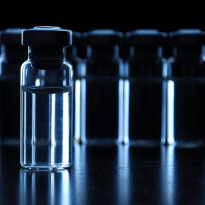 A group of glass vials on a dark surface.