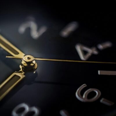 A close up of a clock on a black background.