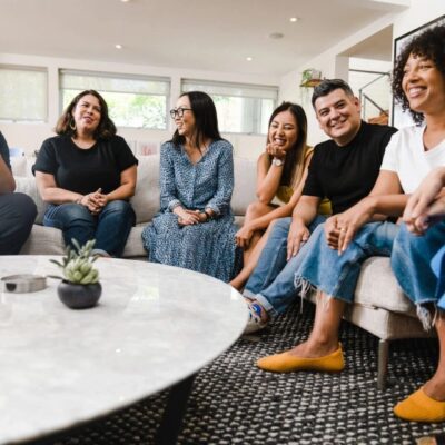 Friends gathered on a couch, smiling.