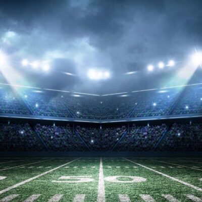 An american football stadium with spotlights on the field.