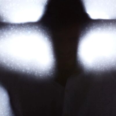 A silhouette of a man standing in front of a window.