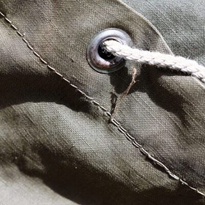A close up of a knot on a green canvas bag.