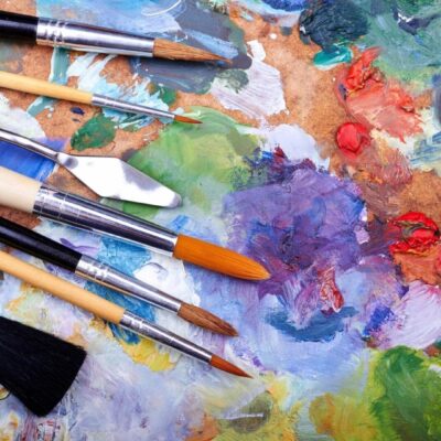 A colorful artist's palette with paintbrushes and mixed paints.